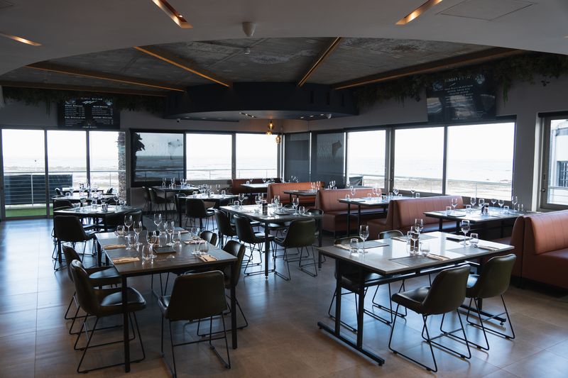 Tables set for dining beside the sea-facing windows at Prime Wagyu