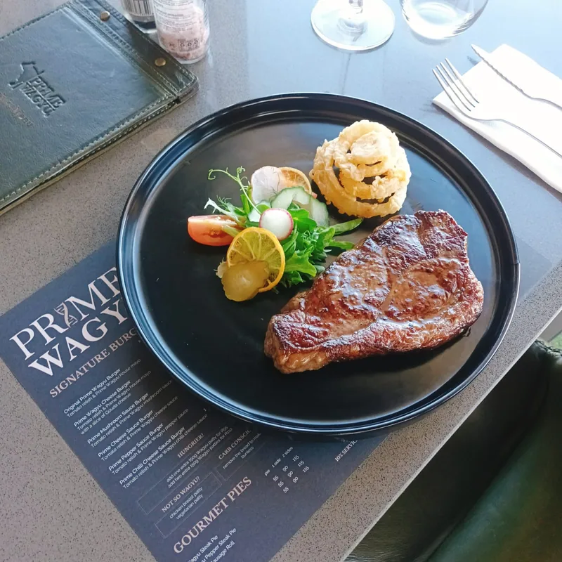 Grilled Wagyu steak with onion rings and salad at Prime Wagyu